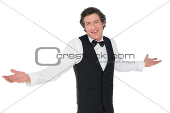 Smiling waiter shrugging over white background