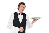 Happy waiter holding tray against white background