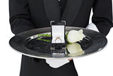 Mid section of waiter presenting engagement ring and rose