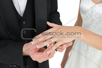 Bride and groom exchanging wedding ring