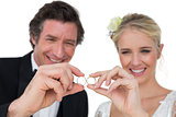 Happy bride and groom looking at wedding rings