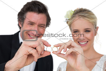 Happy bride and groom looking at wedding rings