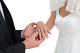Loving groom and bride exchanging wedding ring