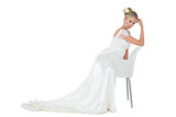 Confident bride leaning on chair over white background