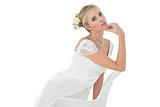 Confident bride with hand on chin leaning on chair