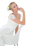 Bride with eyes closed leaning on chair