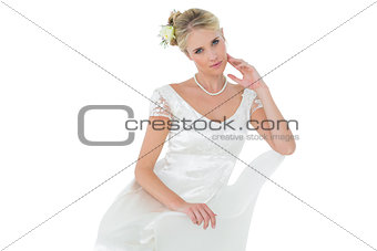 Sensuous bride sitting on chair over white background