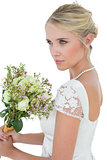 Bride holding flower bouquet while looking away