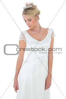 Shy bride with eyes closed against white background