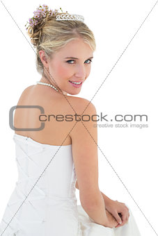 Smiling bride sitting against white background