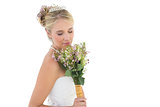 Bride smelling flower bouquet over white background