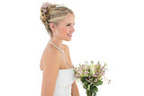 Happy bride with flower bouquet looking away