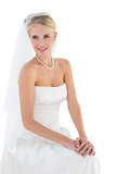 Thoughtful bride smiling against white background