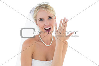 Surprised bride showing wedding ring over white background