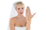 Surprised bride showing wedding ring against white background