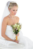 Thoughtful bride holding flower bouquet
