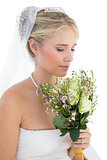 Bride smelling bouquet over white background