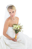 Thoughtful bride holding rose bouquet