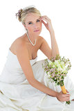 Sensuous bride holding rose bouquet over white background