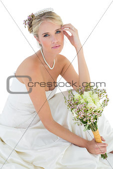 Sensuous bride holding rose bouquet over white background