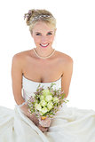 Bride holding flower bouquet against white background