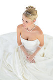 Bride thinking while sitting over white background