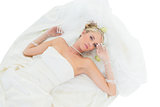 Sensuous bride lying against white background