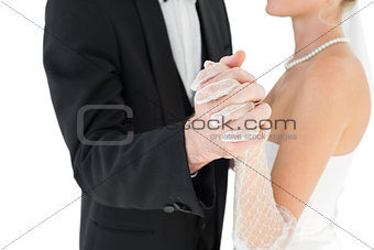 Mid section of bride and groom holding hands