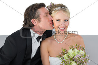 Happy bride being kissed by groom