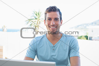 Portrait of a smiling man using laptop