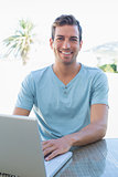 Smiling young man using laptop