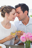Loving couple toasting wine glasses at lunch table