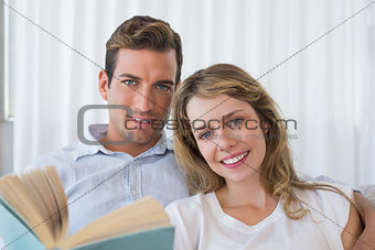 Relaxed young couple reading book at home