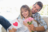 Couple with flowers and greeting card at home