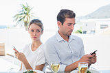 Couple text messaging at food table