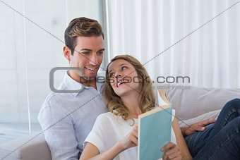 Young couple reading book on couch