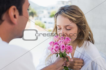 Man giving happy woman flowers at home