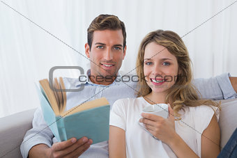 Relaxed couple reading book on couch