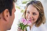 Close-up of man giving happy woman flowers