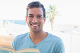 Portrait of a smiling man reading book