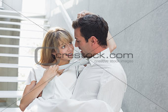 Man carrying woman against stairs