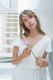Thoughtful beautiful woman with a flower