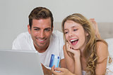 Happy young couple doing online shopping