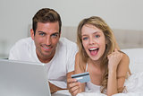 Happy young couple doing online shopping