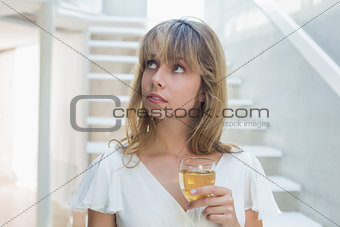 Thoughtful beautiful young woman with wine glass