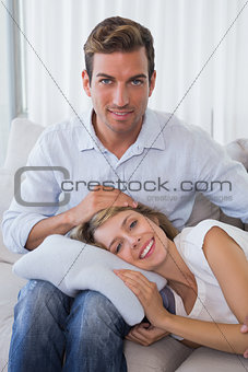 Happy woman resting on mans lap on couch