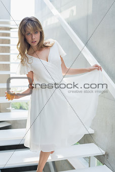 Portrait of a beautiful woman with wine glass on stairs