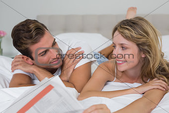 Loving young couple lying in bed
