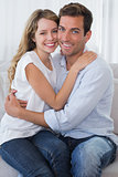 Loving young couple embracing on couch