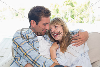 Loving couple sitting on couch at home